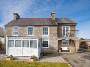 a large brick house with a white garage at Seiriol View in Moelfre