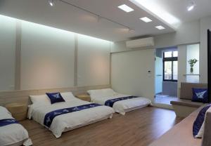 um quarto com duas camas e um sofá em 藴慢築 茶花藝主題民宿 Yun Man Zhu Homestay em Gongguan