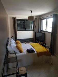 sypialnia z łóżkiem z żółtą pościelą i oknem w obiekcie escapade in Amiens w Amiens