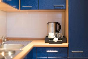 a kitchen with blue cabinets and a sink at City-Hotel Am Wasserturm Halle in Halle an der Saale