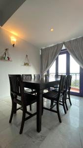 uma sala de jantar com uma mesa preta e duas cadeiras em Sugar Marina Seaview Families Suite Apartment em Kuah