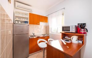 kuchnia z lodówką ze stali nierdzewnej i drewnianym stołem w obiekcie Amazing Apartment In Krusevo w mieście Kruševo