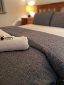Una toalla enrollada encima de una cama en The Coramba Hotel en Coramba