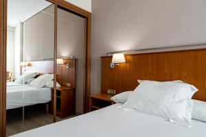 A bed or beds in a room at Hotel Ciudad de Compostela