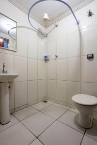 a bathroom with a toilet and a sink at Hotel Romaria Aparecida in Aparecida