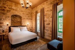a bedroom with a white bed and a window at Olive Heleni Hotel in Jerusalem