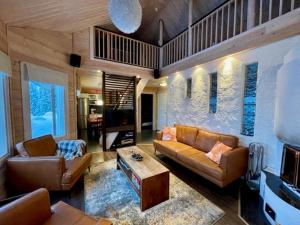 a living room with a couch and a table at Hietavilla Aurora - Hot tube - Sauna - AC - Fireplace - 11kW EV-refuel - Landscape view - Silence - Free WiFi in Ruka
