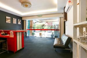 una habitación con un mostrador rojo y un bar con un banco en OYO 90460 Hotel Kl2f Rest & Go, en Shah Alam