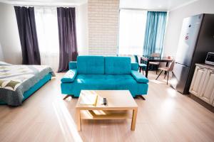a living room with a blue couch and a table at ATLANT Apartments 158а in Voronezh