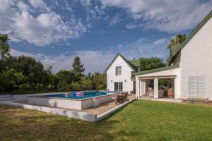 une arrière-cour avec une piscine et une maison dans l'établissement Eden Studios, à Riebeek-Kasteel