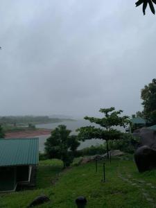 a view of a body of water with trees and a building at Diga vista resorts in Palakkad
