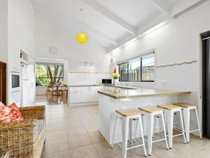 een keuken met witte muren en een aanrecht met krukken bij Maybloom in Rye