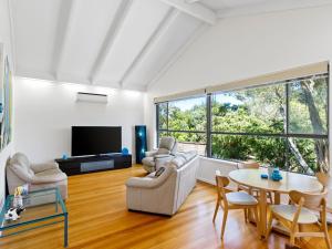 een woonkamer met een tafel en stoelen en een televisie bij Maybloom in Rye