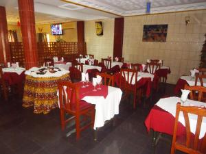 een restaurant met rode en witte tafels en stoelen bij HOTEL SAFFANA in Douala