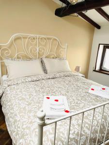 Una cama con dos cartas encima. en La Casa dell'Arco, en Vitorchiano