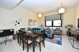 un soggiorno con tavolo, sedie e divano di Lovely 1 Bedroom Apartment in Greens - ADN a Dubai