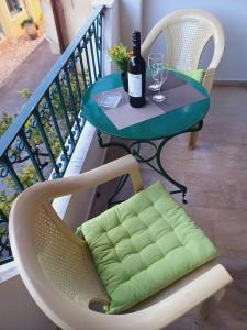 uma mesa com uma garrafa de vinho e copos numa varanda em Demy's Studio em Acharavi
