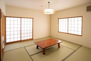 a living room filled with furniture and a window at Kusatsu Onsen Eidaya in Kusatsu