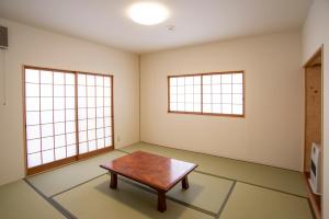 a living room filled with furniture and a window at Kusatsu Onsen Eidaya in Kusatsu