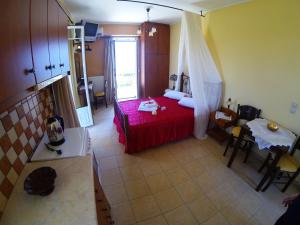 a bedroom with a red bed and a table at Remenata in Lixouri