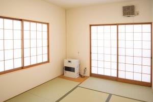 a room with a white wall and a black and white checkered floor at Kusatsu Onsen Eidaya in Kusatsu
