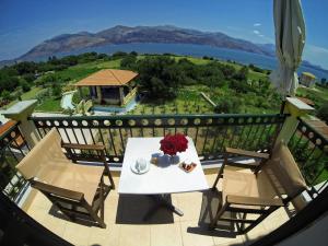 a table and chairs on a balcony with a view at Remenata in Lixouri
