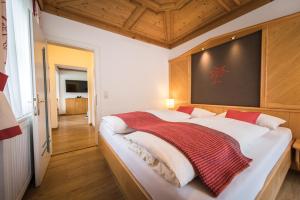 Un dormitorio con una cama grande con una manta roja. en Landhaus Rohrmoser, en Werfenweng