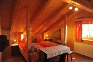 a bedroom with a bed in a wooden room at Almgasthaus Flecknerhütte in San Leonardo in Passiria