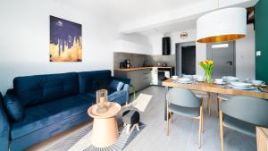 Domki Sun & Snow Sikorskiego في كارباش: غرفة معيشة مع أريكة زرقاء وطاولة