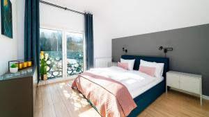 Domki Sun & Snow Sikorskiego في كارباش: غرفة نوم بسرير ونافذة كبيرة