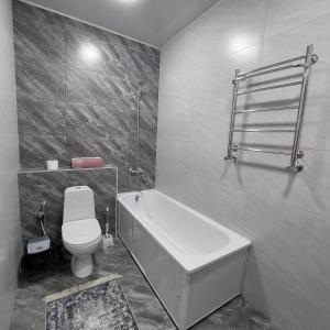 ein Badezimmer mit einer Badewanne, einem WC und einem Waschbecken in der Unterkunft Little Shangri-La in Almaty
