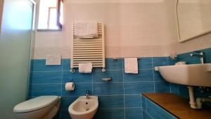 a blue tiled bathroom with a sink and a toilet at Cocos Park Ischia in Ischia +25 photos