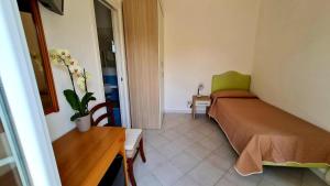 a bedroom with a bed and a table and a chair at Cocos Park Ischia in Ischia