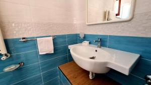 a bathroom with a white sink and a mirror at Cocos Park Ischia in Ischia