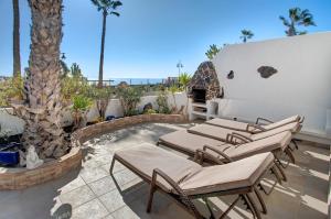 a patio with chaise lounge chairs and a swimming pool at Puerto Chico P in Playa Blanca
