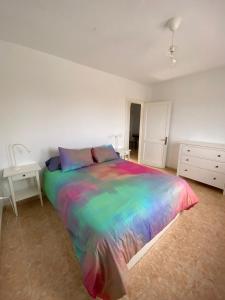 1 dormitorio con cama colorida y escritorio en Villa Tranquila, en Orzola