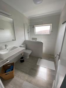 a bathroom with a sink and a toilet and a window at Villa Tranquila in Orzola +19 photos
