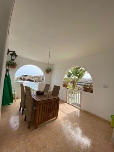 a dining room with a wooden table and chairs at Villa Tranquila in Orzola