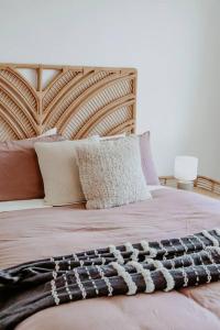 Cama con cabecero de madera y almohadas en Coastaways, en Port Campbell