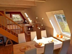 a dining room with a table and chairs and a staircase at Arche in Brodersby