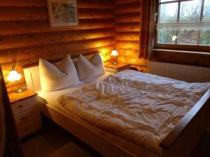 a bedroom with a large bed with pillows and a window at Block Hus in Hasselberg