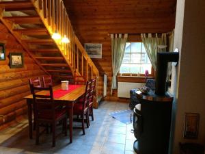 a dining room with a table and chairs and a stove at Block Hus in Hasselberg