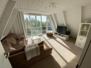 a living room with a couch and a television at Leichte Brise in Brodersby