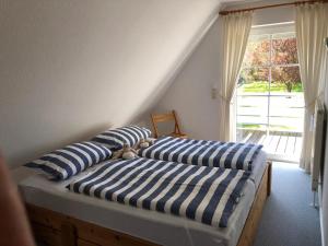 two beds with blue and white striped pillows in a room at Penaten in Boren