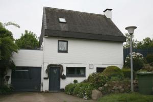 a white house with a black roof and a driveway at Schlei-Juwel in Brodersby