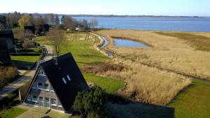 eine Luftaufnahme eines Hauses neben einem Gewässer in der Unterkunft Weitblick in Brodersby