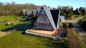 ein kleines Haus mit einer Terrasse im Gras in der Unterkunft Weitblick in Brodersby