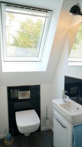 a bathroom with a white toilet and a window at Utspann in Brodersby