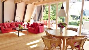 a living room with a red couch and a table at Schleistern in Brodersby