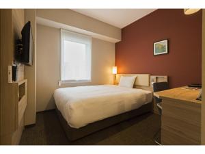 a hotel room with a bed and a window at KEIKYU EX INN Keikyu Kawasaki-Station in Kawasaki